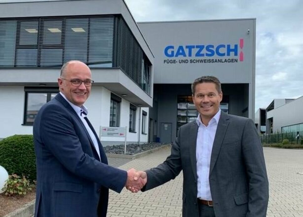 Martin Gatzsch and Hannes Feuerhuber shake hands in front of the Gatzsch Schweißtechnik company building.