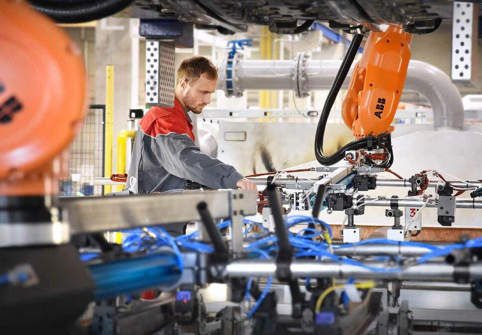 A technician from weba is working on a state-of-the-art production system with robotic elements. The mobile toolmaking service ensures precise installation and integration of forming and stamping tools into the production environment.