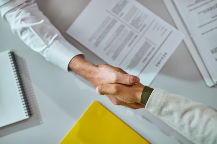Career Change: Successfully Navigating a Job Transition Shaking hands after a successful agreement over signed contracts. The image symbolizes the signing of a contract for a career change.
